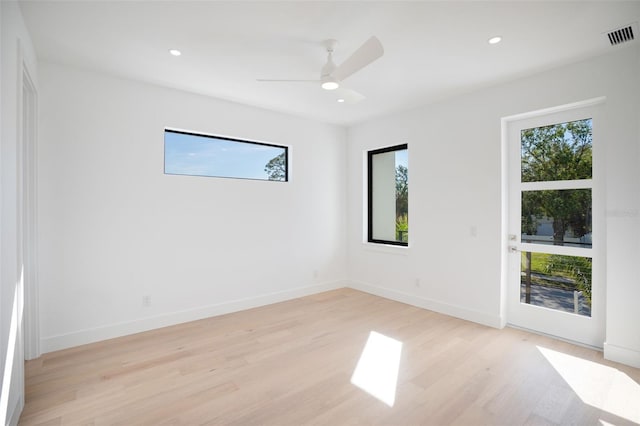 empty room featuring light wood-style flooring, visible vents, baseboards, and recessed lighting