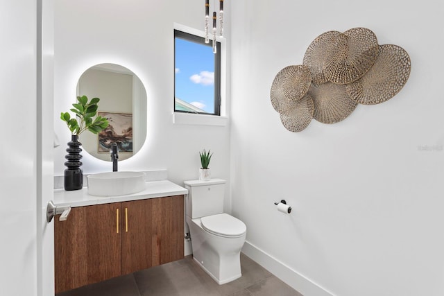 bathroom with tile patterned floors, vanity, toilet, and baseboards