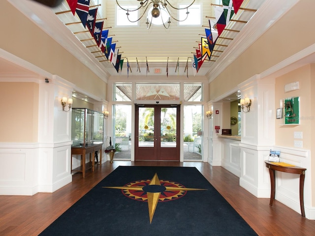 entryway featuring ornamental molding, a notable chandelier, french doors, and dark hardwood / wood-style flooring