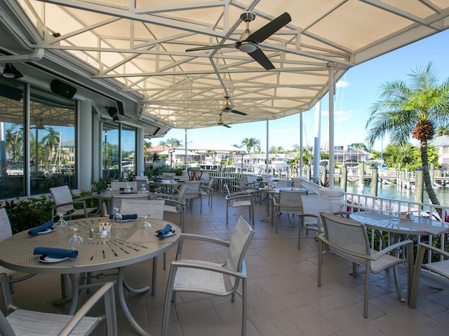 view of patio with a water view and ceiling fan