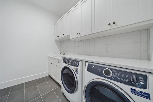 laundry area featuring cabinets, washer and clothes dryer, sink, and dark tile patterned floors