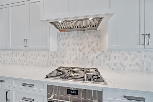 kitchen with stainless steel gas stovetop, white cabinets, and oven