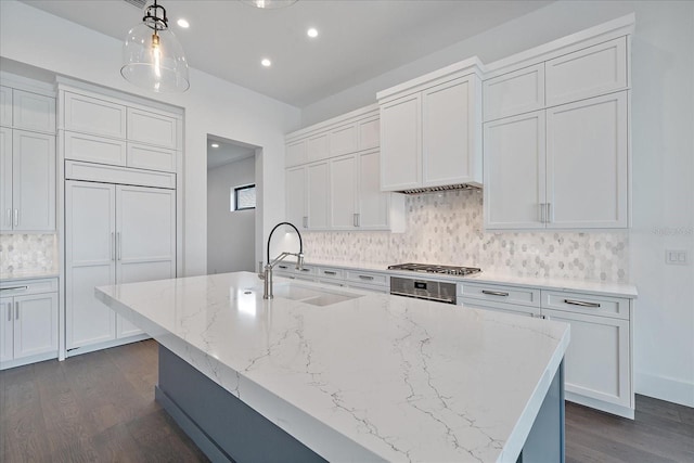 kitchen featuring white cabinetry, sink, pendant lighting, and decorative backsplash