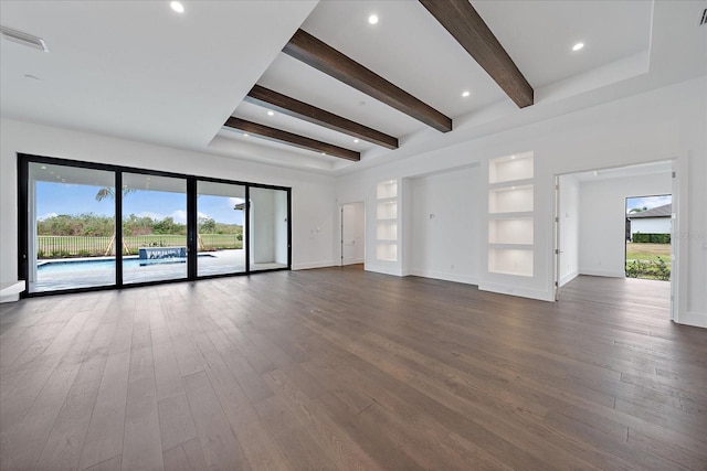 unfurnished living room with beam ceiling, dark hardwood / wood-style floors, and a wealth of natural light