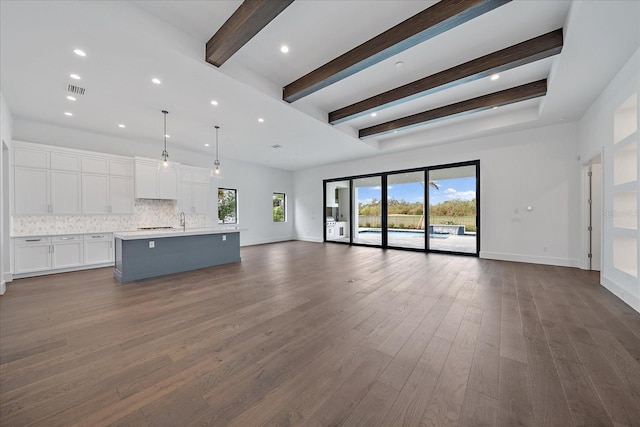 unfurnished living room with beam ceiling, dark hardwood / wood-style floors, and sink