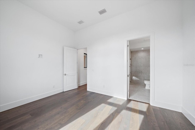 unfurnished bedroom with connected bathroom and dark hardwood / wood-style flooring