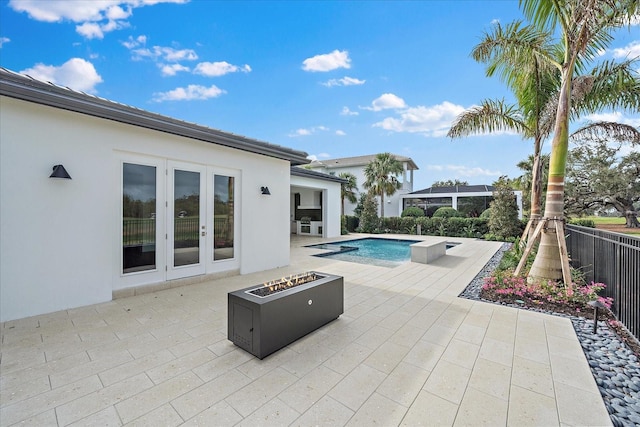 view of pool with a patio area, french doors, and a fire pit