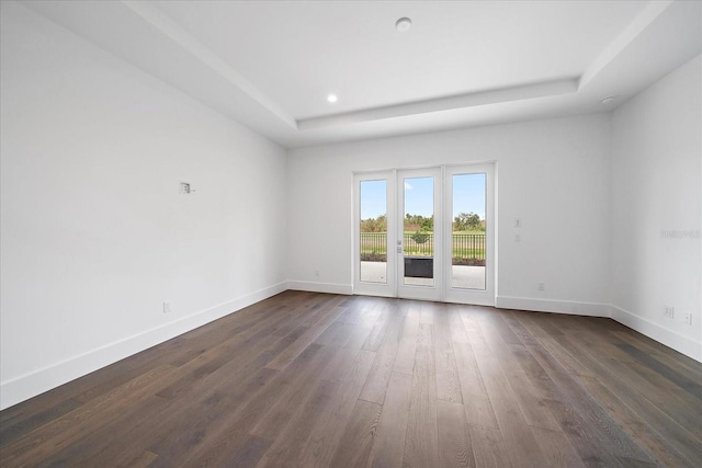 empty room featuring dark hardwood / wood-style flooring and a raised ceiling