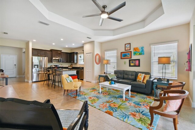4618 Deep Creek Ter, Parrish, FL 34219 - living room featuring light tile floors, ceiling fan, a tray ceiling, and a wealth of natural light