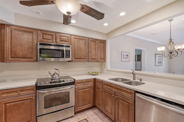 kitchen with stainless steel appliances, light tile floors, ceiling fan with notable chandelier, hanging light fixtures, and sink