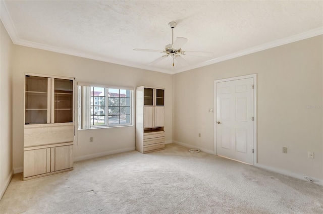 empty room with light carpet, crown molding, and ceiling fan