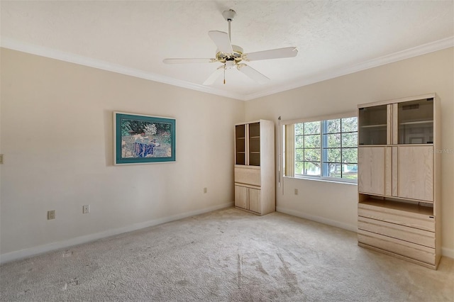 unfurnished bedroom with crown molding, light colored carpet, and ceiling fan