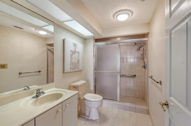 bathroom featuring toilet, tile floors, a shower with shower door, and vanity