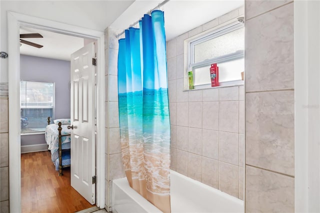 bathroom with shower / tub combo with curtain, wood-type flooring, and ceiling fan