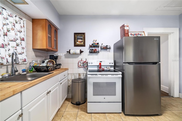 kitchen with stainless steel fridge, white electric range, tasteful backsplash, and sink