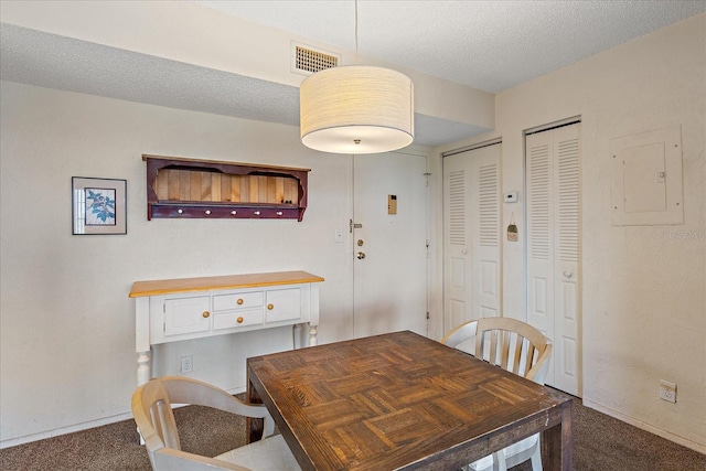 dining room with carpet flooring and a textured ceiling