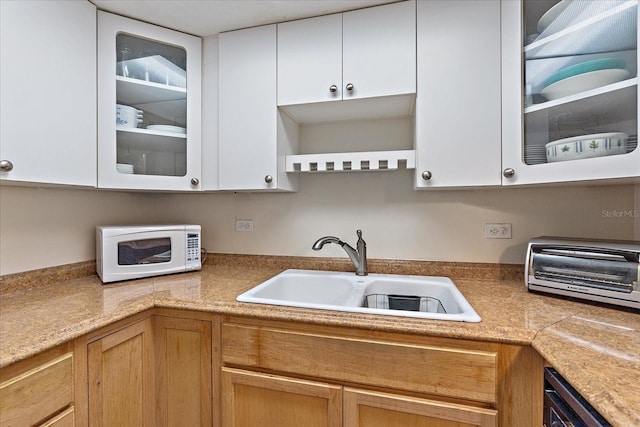 kitchen featuring white cabinets and sink