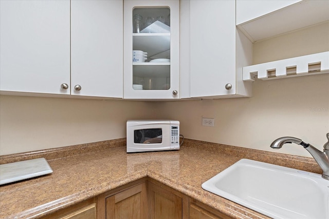 kitchen featuring white cabinetry and sink