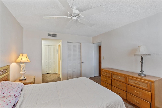 bedroom featuring a textured ceiling, ceiling fan, and dark carpet