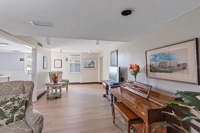 misc room with a textured ceiling and light hardwood / wood-style flooring