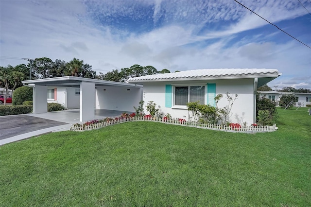 ranch-style house with a tile roof, stucco siding, a carport, driveway, and a front lawn