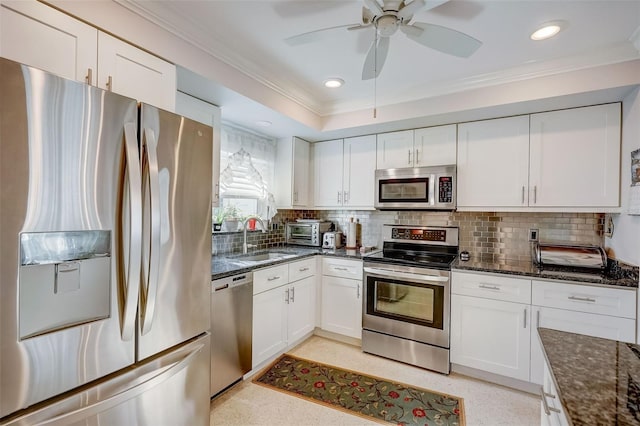 kitchen featuring stainless steel appliances, sink, decorative backsplash, and white cabinetry