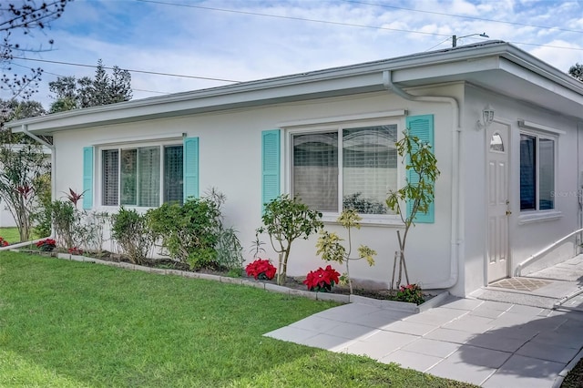 view of property exterior featuring a yard and stucco siding