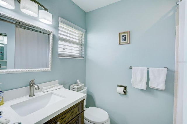 bathroom featuring a shower with curtain, toilet, and vanity