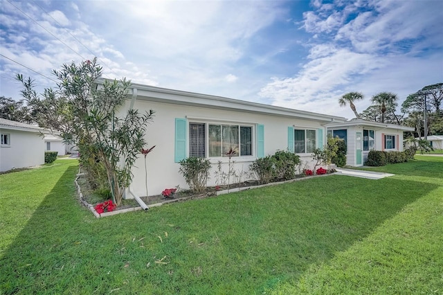 view of front of home with a front lawn and stucco siding