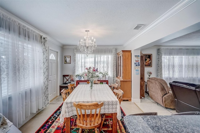 dining room with a chandelier, visible vents, crown molding, and a textured ceiling