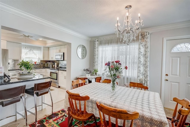 dining room featuring ornamental molding, a textured ceiling, and ceiling fan with notable chandelier