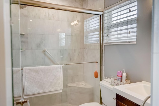 bathroom with vanity, toilet, and a shower with shower door