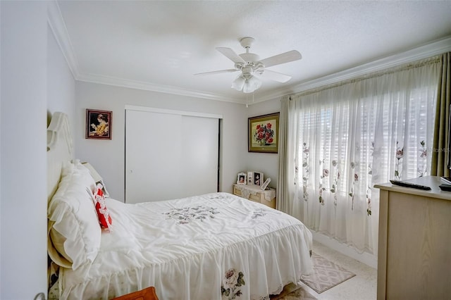 bedroom featuring light carpet, a closet, a ceiling fan, and crown molding