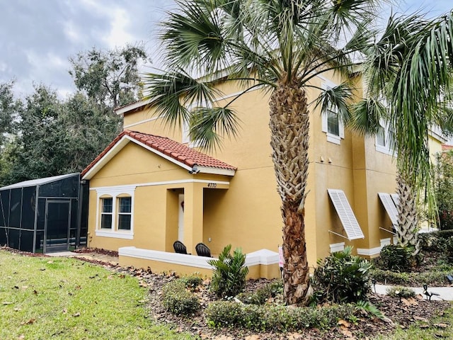 rear view of house featuring a sunroom and a lawn