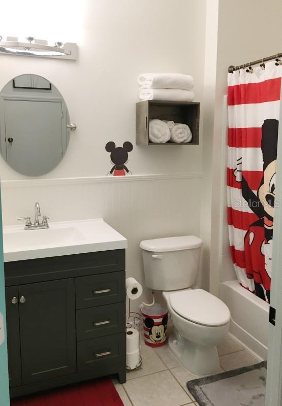 full bathroom with tile floors, toilet, vanity, and shower / bath combo