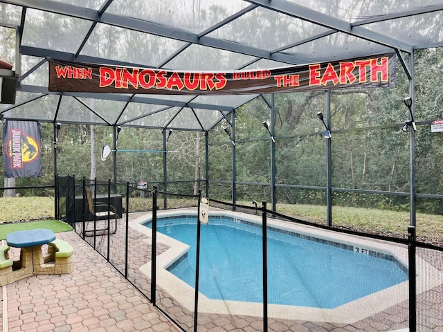 view of pool featuring glass enclosure and a patio area