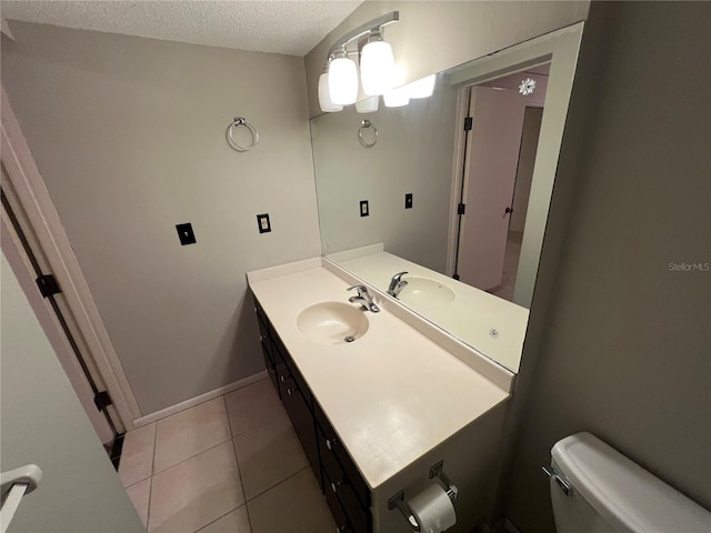 bathroom featuring a textured ceiling, tile flooring, toilet, and large vanity