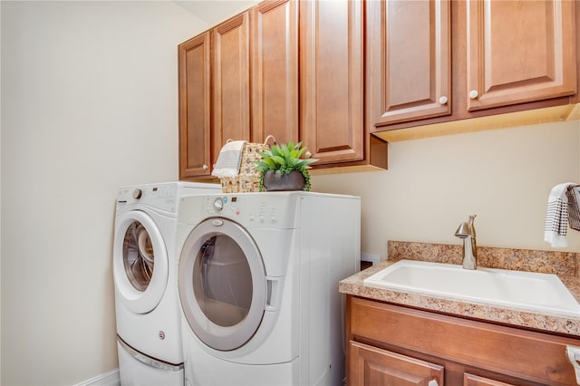 laundry room with washing machine and clothes dryer, sink, and cabinets