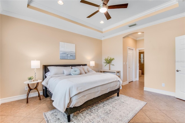 tiled bedroom featuring a raised ceiling, ceiling fan, a closet, and ornamental molding