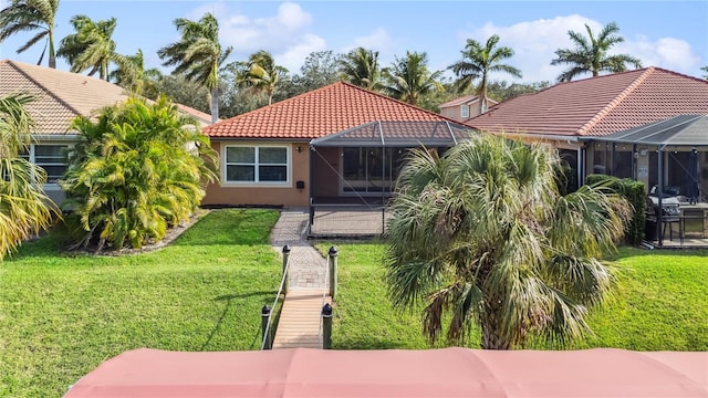 back of house featuring a lanai and a yard