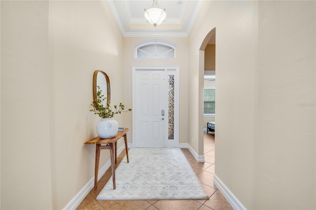 entryway with light tile patterned floors and ornamental molding