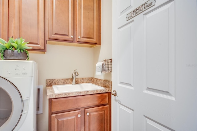 laundry area with sink, cabinets, and washer / dryer