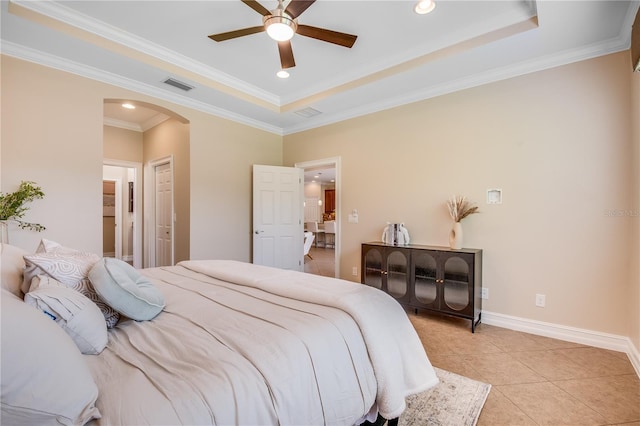 tiled bedroom featuring ceiling fan, ornamental molding, and a tray ceiling