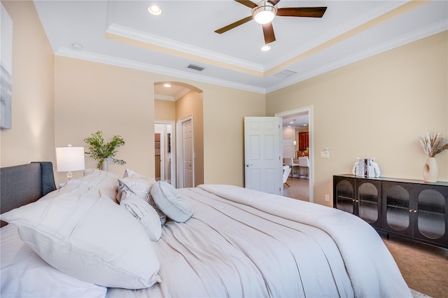 bedroom featuring tile patterned flooring, ceiling fan, a raised ceiling, and crown molding