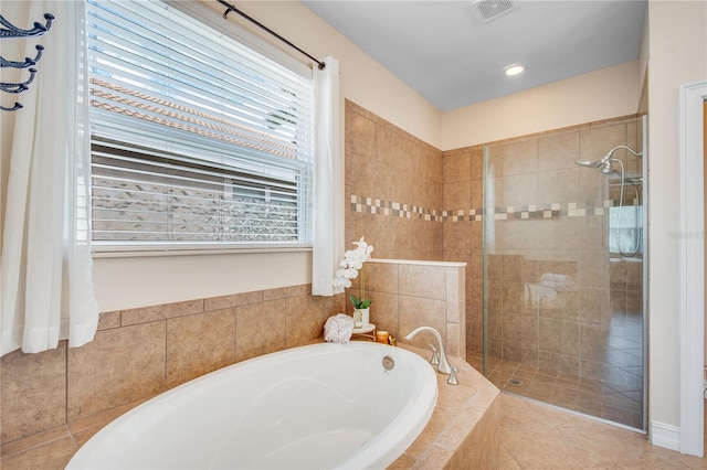 bathroom with tile patterned floors and shower with separate bathtub