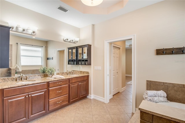 bathroom featuring tile patterned flooring, vanity, and a raised ceiling