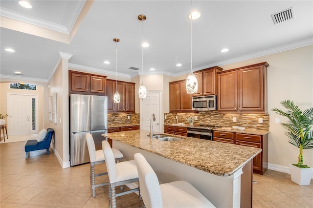 kitchen with tasteful backsplash, an island with sink, decorative light fixtures, appliances with stainless steel finishes, and ornamental molding