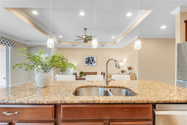 kitchen featuring crown molding, sink, ceiling fan, a tray ceiling, and decorative light fixtures