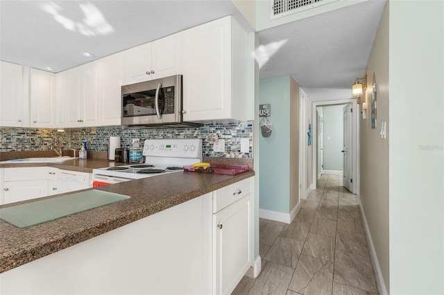 kitchen featuring white cabinets, white range with electric cooktop, and backsplash