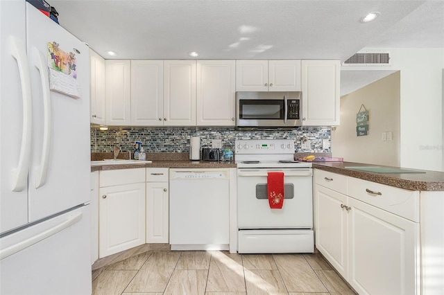 kitchen featuring backsplash, white appliances, white cabinets, and light tile floors